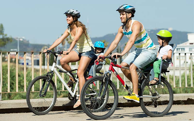 szülők gyermekeikkel kerékpároznak